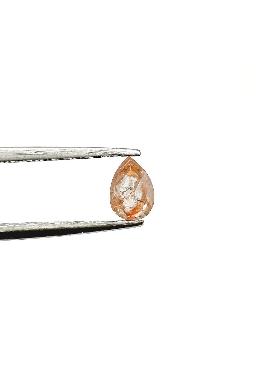 Close-up on white background of a unique and natural pear-cut peach diamond